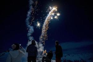 bonne année et joyeux noël feux d'artifice sur fond de neige de montagne photo