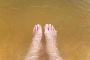 jambes masculines dans l'eau de mer photo