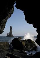 Vagues venant à la plage noire de Reynisfjara, Islande, avec des formations rocheuses en arrière-plan photo