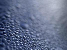 gouttes d'eau de rosée sur une surface métallique bleue photo