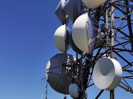 tour d'antenne de communication cellulaire sur fond bleu photo