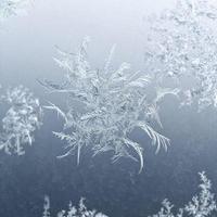 flocon de neige gros plan sur la vitre de la fenêtre en hiver photo