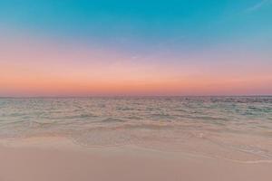 gros plan plage de sable de mer. incroyable paysage de plage vide. inspirer l'horizon du paysage marin de l'île tropicale. orange doré violet coucher de soleil lever du soleil ciel tranquille lumière du soleil. vacances d'été voyage vacances copie espace photo