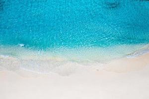 scène de plage aérienne relaxante, bannière de modèle de vacances de vacances d'été. les vagues surfent avec un incroyable lagon bleu océan, bord de mer, littoral. vue de dessus de drone aérien parfait. plage lumineuse paisible, bord de mer photo