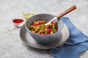 quinoa avec haricots verts, tomates, champignons frits, maïs, poivrons rouges, pois et soja. mélange de légumes sains