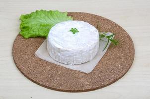 Fromage brie sur planche de bois et fond de bois photo