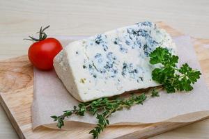 Fromage bleu sur planche de bois et fond de bois photo