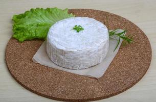 Fromage brie sur planche de bois et fond de bois photo