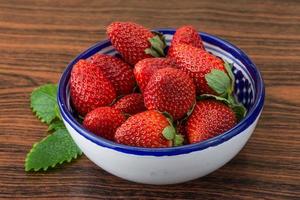 Fraise fraîche dans un bol sur fond de bois photo