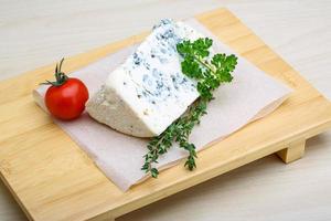 Fromage bleu sur planche de bois et fond de bois photo