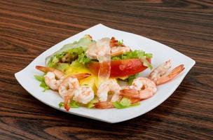 crevettes avec salade d'aloe vera sur l'assiette et fond en bois photo