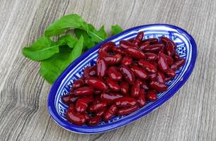 haricots rouges dans un bol sur fond de bois photo