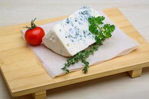 Fromage bleu sur planche de bois et fond de bois photo