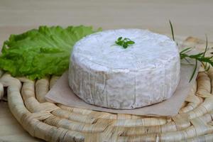 Fromage brie sur planche de bois et fond de bois photo