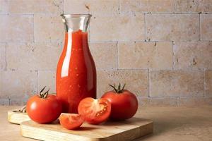 bouteille en verre avec sauce tomate maison et tomates mûres