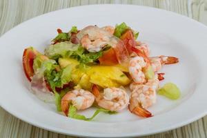 crevettes avec salade d'aloe vera sur l'assiette et fond en bois photo