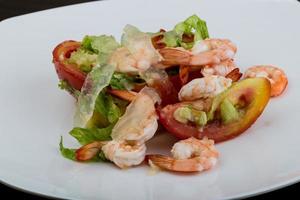 crevettes avec salade d'aloe vera sur l'assiette et fond en bois photo