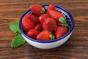 Fraise fraîche dans un bol sur fond de bois photo