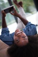 femme afro-américaine à la maison avec tablette numérique photo