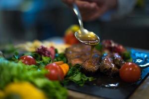 assiette de viande de steak de finition à la main du chef photo