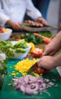 mains de chef coupant des légumes frais et délicieux photo