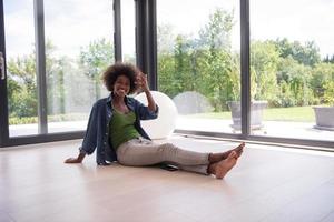 femme afro-américaine assise près de la fenêtre photo