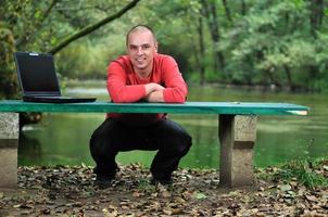 jeune homme d'affaires travaillant sur un ordinateur portable en plein air photo