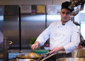 chef préparant la nourriture, faisant frire dans la casserole de wok photo