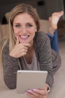 les jeunes femmes ont utilisé un ordinateur tablette sur le sol photo