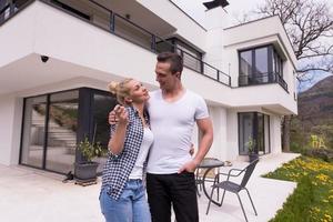 couple s'embrassant devant une nouvelle maison de luxe photo