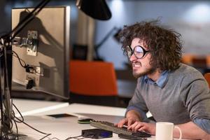 homme travaillant sur ordinateur dans un bureau de démarrage sombre photo