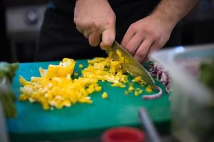 mains de chef coupant des légumes frais et délicieux photo