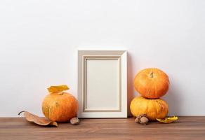 maquette de cadre photo d'art avec écharpes et feuilles d'automne, fond blanc