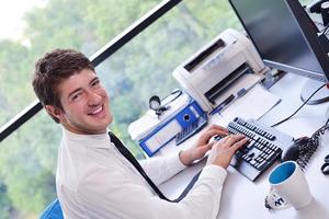 heureux jeune homme d'affaires au bureau photo