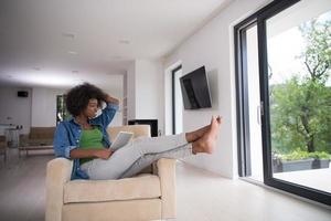 femme afro-américaine à la maison avec tablette numérique photo