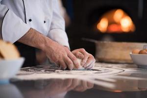 mains de chef préparant la pâte pour la pizza photo