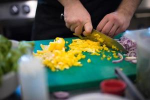 mains de chef coupant des légumes frais et délicieux photo