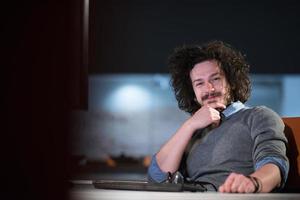 homme travaillant sur ordinateur dans un bureau de démarrage sombre photo