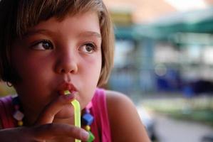 mignon petit fille appréciant une boisson froide photo