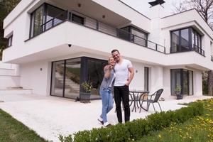 couple s'embrassant devant une nouvelle maison de luxe photo