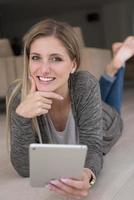 les jeunes femmes ont utilisé un ordinateur tablette sur le sol photo