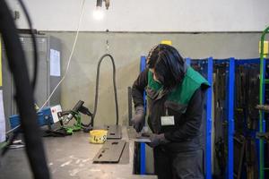 une femme travaillant dans l'industrie moderne de la production et de la transformation des métaux soudant le produit et le préparant pour une machine cnc photo