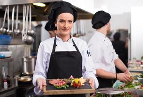 femme chef tenant une assiette de steak de boeuf photo