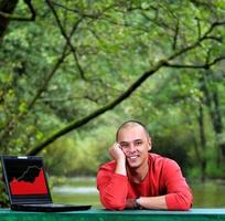 jeune homme d'affaires en plein air travaillant sur un ordinateur portable photo