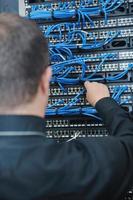 jeune ingénieur informatique dans la salle des serveurs du centre de données photo