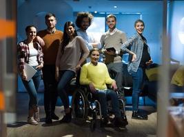 femme d'affaires handicapée en fauteuil roulant au bureau avec l'équipe de collègues photo