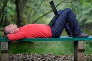 jeune homme d'affaires en plein air travaillant sur un ordinateur portable photo