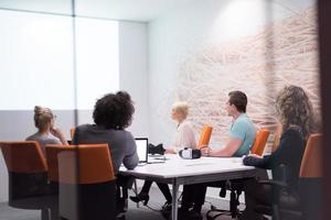 équipe commerciale de démarrage lors d'une réunion dans un immeuble de bureaux de nuit moderne photo