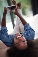 femme afro-américaine à la maison avec tablette numérique photo