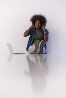 femme afro-américaine assise sur le sol avec un ordinateur portable